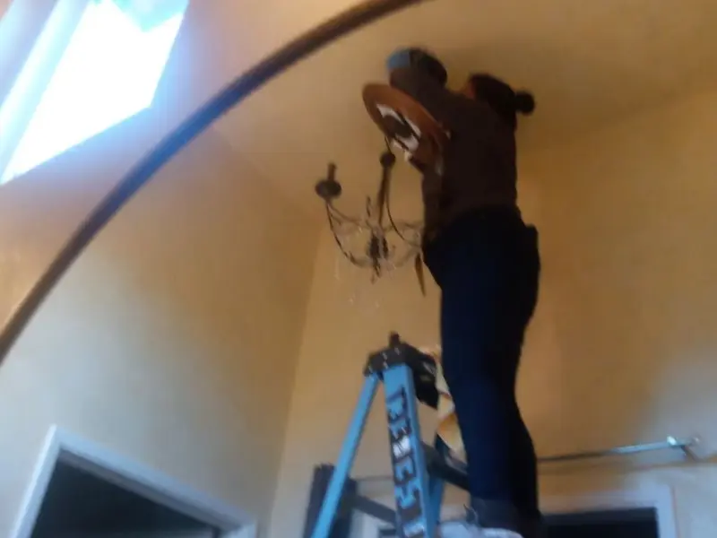 Electrician installing a chandelier in a Waterloo residence